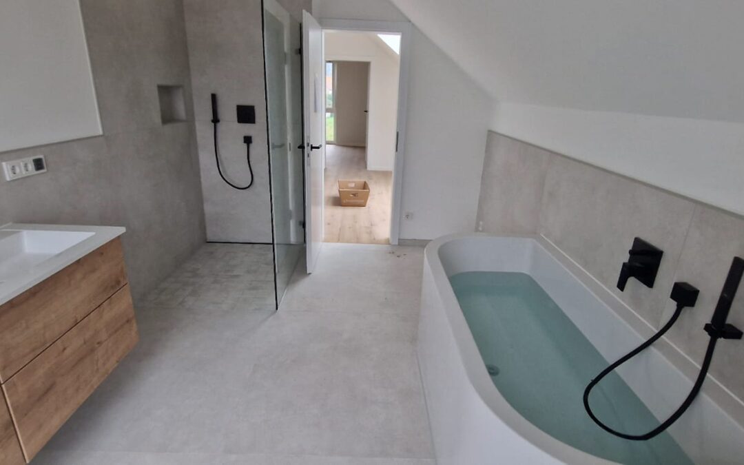 Modernes Badezimmer mit freistehender Badewanne, bodengleicher Dusche und schwarzen Armaturen nach Renovierung durch PC Trockenbau